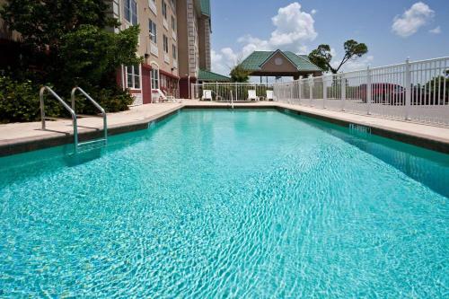 a large blue swimming pool in front of a building at Country Inn & Suites by Radisson, Port Charlotte, FL in Port Charlotte