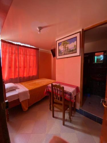 a bedroom with a bed and a table and a window at Hospedaje el Poseidon in Chachapoyas