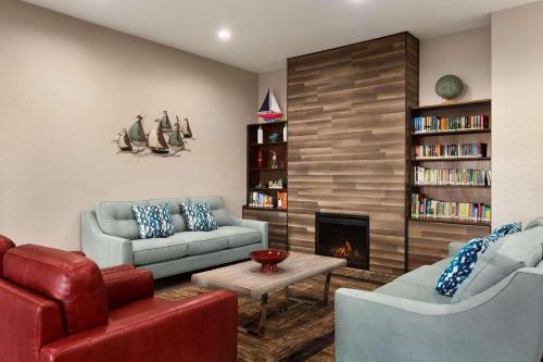 sala de estar con 2 sofás y chimenea en Country Inn & Suites by Radisson, Panama City Beach, FL, en Panama City Beach
