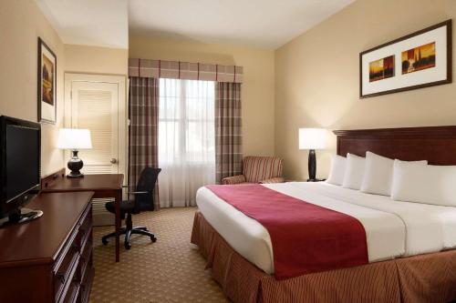 Country Inn & Suites by Radisson, Crestview, FL tesisinde bir odada yatak veya yataklar