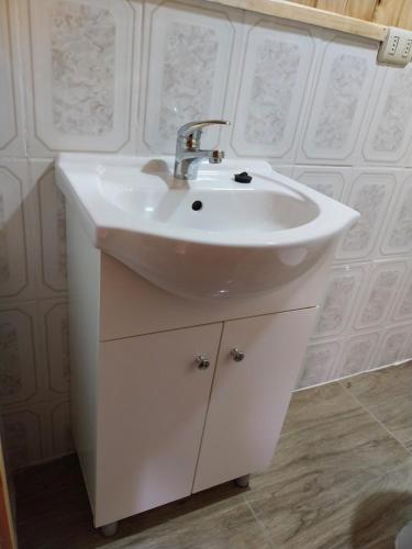 uma casa de banho com um lavatório branco num quarto em Cricri em Castro