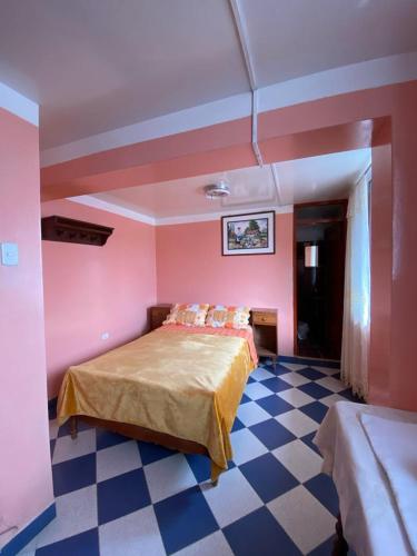 1 dormitorio con paredes rosas y 1 cama con suelo a cuadros en Hospedaje el Poseidon, en Chachapoyas
