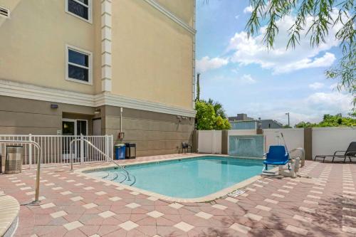 una piscina con una silla azul junto a un edificio en Country Inn & Suites by Radisson, Tampa Airport North, FL, en Tampa