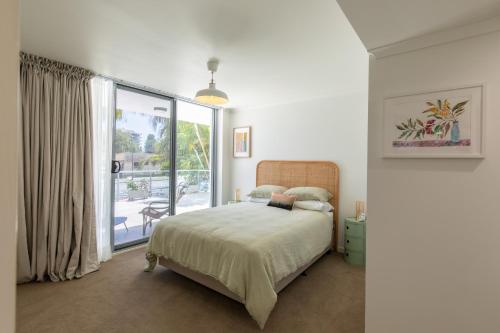 um quarto com uma cama e uma grande janela em 'Sage' at The Crest - Spacious ground floor apartment em Forster