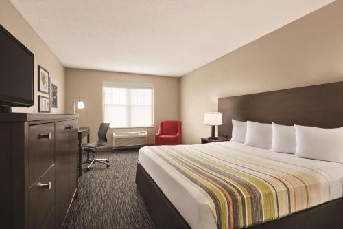a hotel room with a bed and a desk at Country Inn & Suites by Radisson, Tampa-Brandon, FL in Tampa