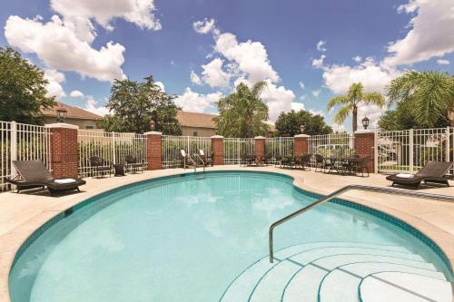 a large swimming pool with chairs and a fence at Country Inn & Suites by Radisson, Tampa-Brandon, FL in Tampa