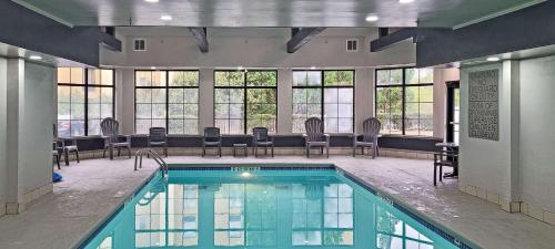 una piscina con sillas y mesas en un edificio en Country Inn & Suites by Radisson, Canton, GA, en Canton
