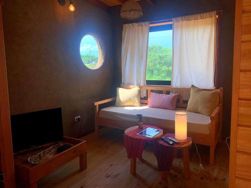 sala de estar con cama y ventana en Nao Tem Fim, en Punta del Diablo