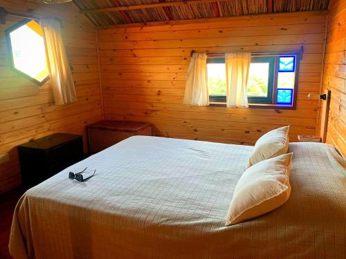 1 dormitorio con 1 cama en una habitación de madera en Nao Tem Fim en Punta del Diablo