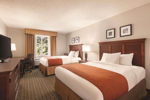 um quarto de hotel com duas camas e uma televisão de ecrã plano em Country Inn & Suites by Radisson, Lawrenceville, GA em Lawrenceville