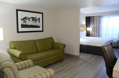 a hotel room with a couch and a bed at Country Inn & Suites by Radisson, Buford at Mall of Georgia, GA in Buford