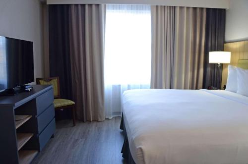 a hotel room with a bed and a large window at Country Inn & Suites by Radisson, Buford at Mall of Georgia, GA in Buford