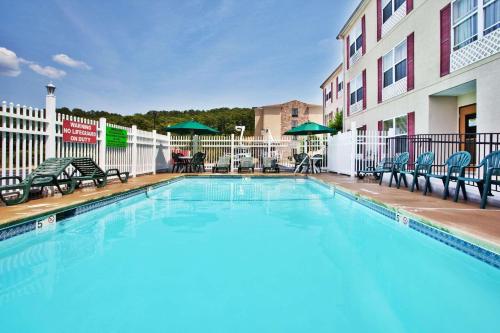 a swimming pool at a hotel with chairs and a building at Country Inn & Suites by Radisson, Rome, GA in Rome
