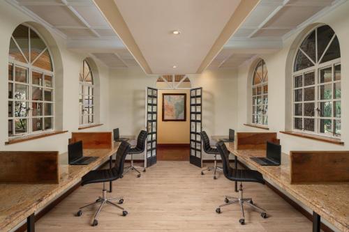 una oficina con escritorios, sillas y ventanas en Fairview Hotel Nairobi en Nairobi