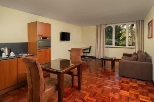 a kitchen and living room with a table and a couch at Fairview Hotel Nairobi in Nairobi