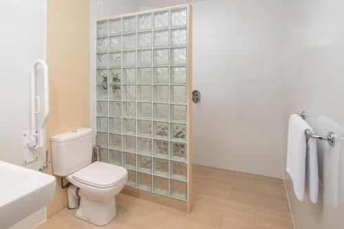 a bathroom with a toilet and a glass shower door at Fairview Hotel Nairobi in Nairobi