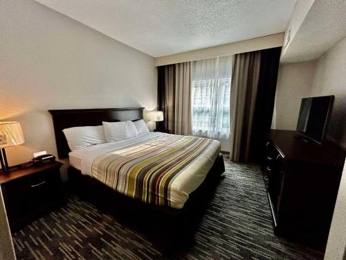 a hotel room with a bed and a television at Country Inn & Suites by Radisson, Columbus, GA in Columbus