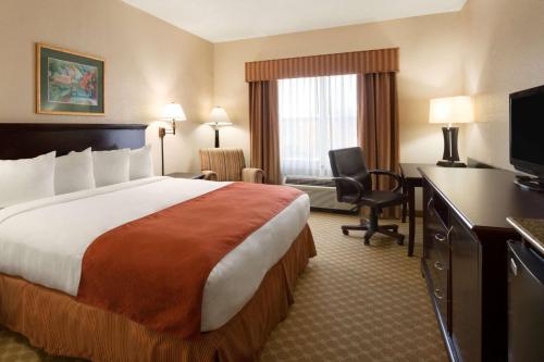 a hotel room with a large bed and a desk at Country Inn & Suites by Radisson, Columbus, GA in Columbus