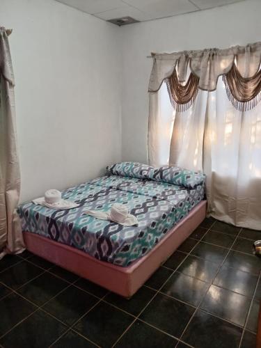 1 cama en una habitación con cortinas en Casa Astridainara, en Puerto Jiménez