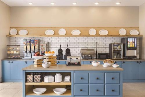 a kitchen with blue cabinets and plates on the wall at Country Inn & Suites by Radisson, Conyers, GA in Conyers
