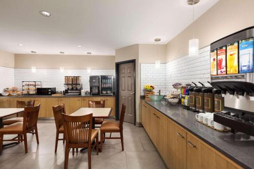 a restaurant with a table and chairs and a kitchen at Country Inn & Suites by Radisson, Dalton, GA in Dalton
