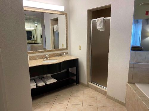 y baño con lavabo, espejo y ducha. en Country Inn & Suites by Radisson, Athens, GA en Athens