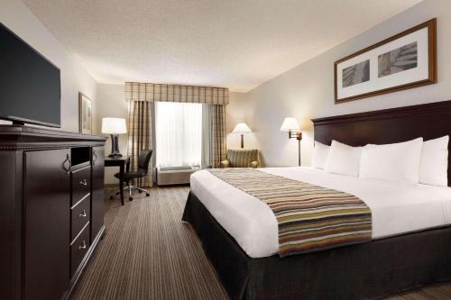 Habitación de hotel con cama grande y TV en Country Inn & Suites by Radisson, Kingsland, GA, en Kingsland