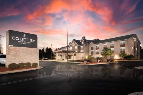 a building with a sign in a parking lot at Country Inn & Suites by Radisson, Stone Mountain, GA in Stone Mountain
