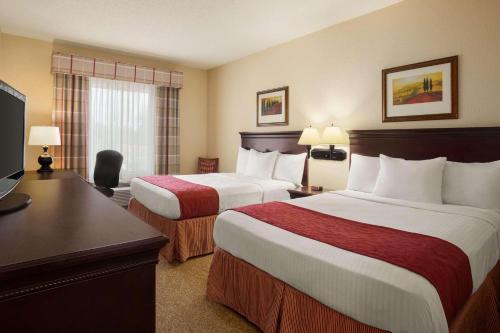 Habitación de hotel con 2 camas y escritorio en Country Inn & Suites by Radisson, Albany, GA en Albany