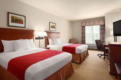 A bed or beds in a room at Country Inn & Suites by Radisson, Tifton, GA