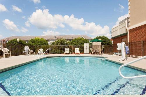 una piscina con sillas, mesa y sillas en Country Inn & Suites by Radisson, Tifton, GA, en Tifton
