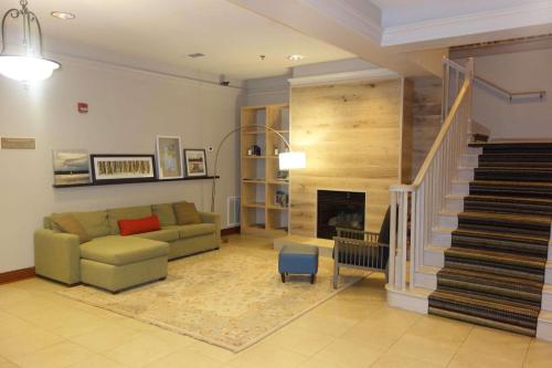 sala de estar con sofá y escalera en Country Inn & Suites by Radisson, Helen, GA, en Helen
