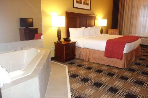 a hotel room with a bed and a bath tub at Country Inn & Suites by Radisson, Helen, GA in Helen