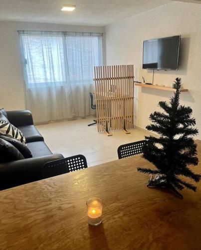 a christmas tree on a wooden table in a living room at Depto. equipado, Dos Habitaciones, Centro Tulancingo in Tulancingo