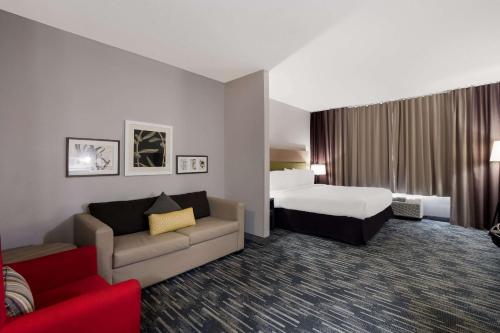a hotel room with a bed and a couch at Country Inn & Suites by Radisson, Augusta at I-20, GA in Augusta