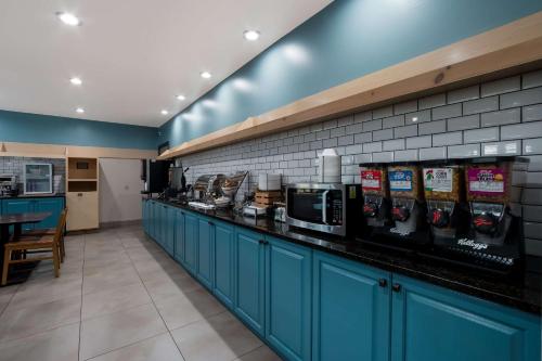 a kitchen with blue cabinets and a counter in a restaurant at Country Inn & Suites by Radisson, Augusta at I-20, GA in Augusta