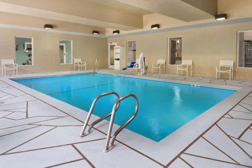 uma piscina num hotel com cadeiras e mesas em Country Inn & Suites by Radisson, Brunswick I-95, GA em Brunswick