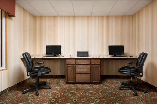 a conference room with two desks with two monitors and chairs at Country Inn & Suites by Radisson, Norcross, GA in Norcross