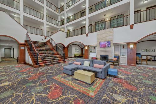 a large lobby with a couch and a staircase at Country Inn & Suites by Radisson, Braselton, GA in Braselton