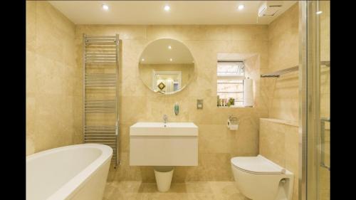 a bathroom with a tub and a toilet and a sink at Alexander House in London