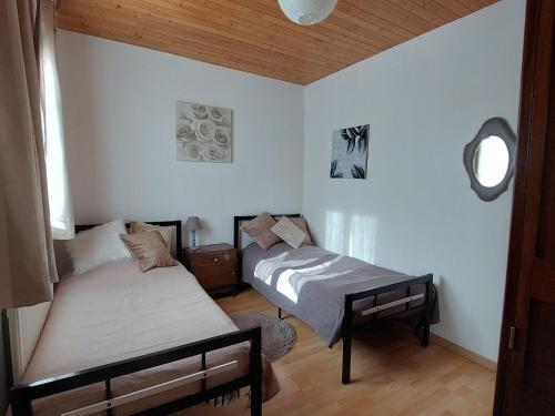 1 Schlafzimmer mit 2 Betten und einem Fenster in der Unterkunft Gîte Velle-sur-Moselle, 3 pièces, 5 personnes - FR-1-584-164 in Velle-sur-Moselle