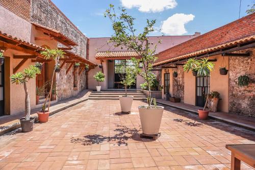 une cour avec des plantes en pot et des escaliers dans un bâtiment dans l'établissement Hacienda Gamboa, à Atlixco