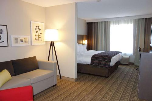 a hotel room with a bed and a couch at Country Inn & Suites by Radisson, Mason City, IA in Mason City
