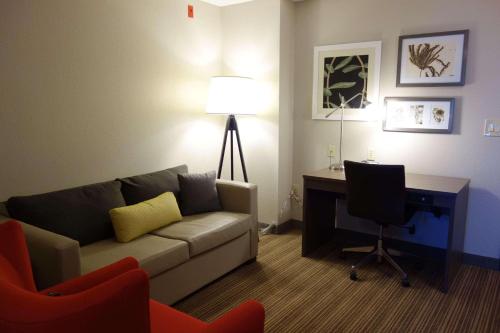 a living room with a couch and a desk with a computer at Country Inn & Suites by Radisson, Mason City, IA in Mason City