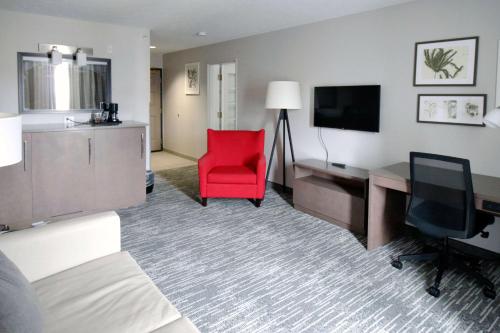 ein Hotelzimmer mit einem Schreibtisch und einem roten Stuhl in der Unterkunft Country Inn & Suites by Radisson, Council Bluffs, IA in Council Bluffs