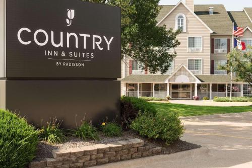 a sign for a community inn and suites at Country Inn & Suites by Radisson, Davenport - Quad Cities in Davenport