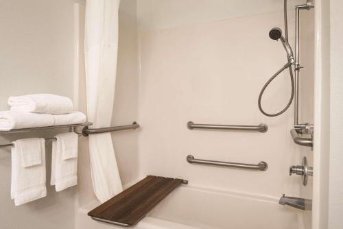 a bathroom with a shower and a toilet with towels at Country Inn & Suites by Radisson, Waterloo, IA in Waterloo