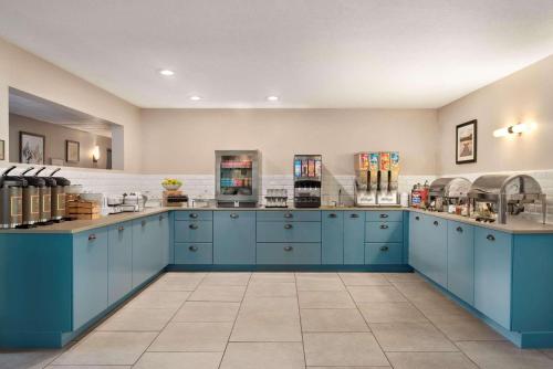 a large kitchen with blue cabinets and a counter at Country Inn & Suites by Radisson, Decorah, IA in Decorah
