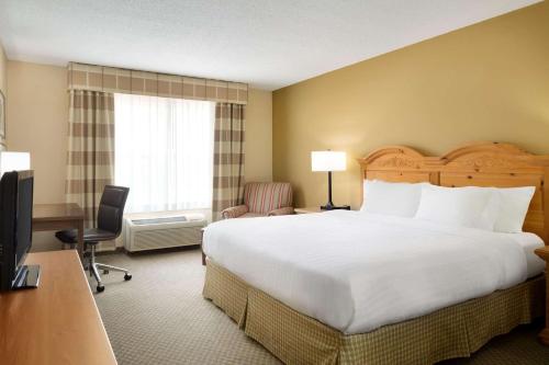 um quarto de hotel com uma cama grande e uma secretária em Country Inn & Suites by Radisson, Grinnell, IA em Grinnell
