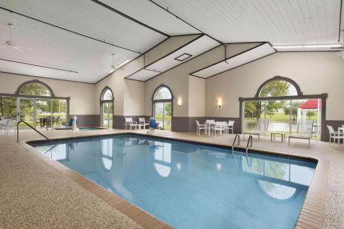 a large swimming pool in a room with tables and chairs at Country Inn & Suites by Radisson, Ankeny, IA in Ankeny